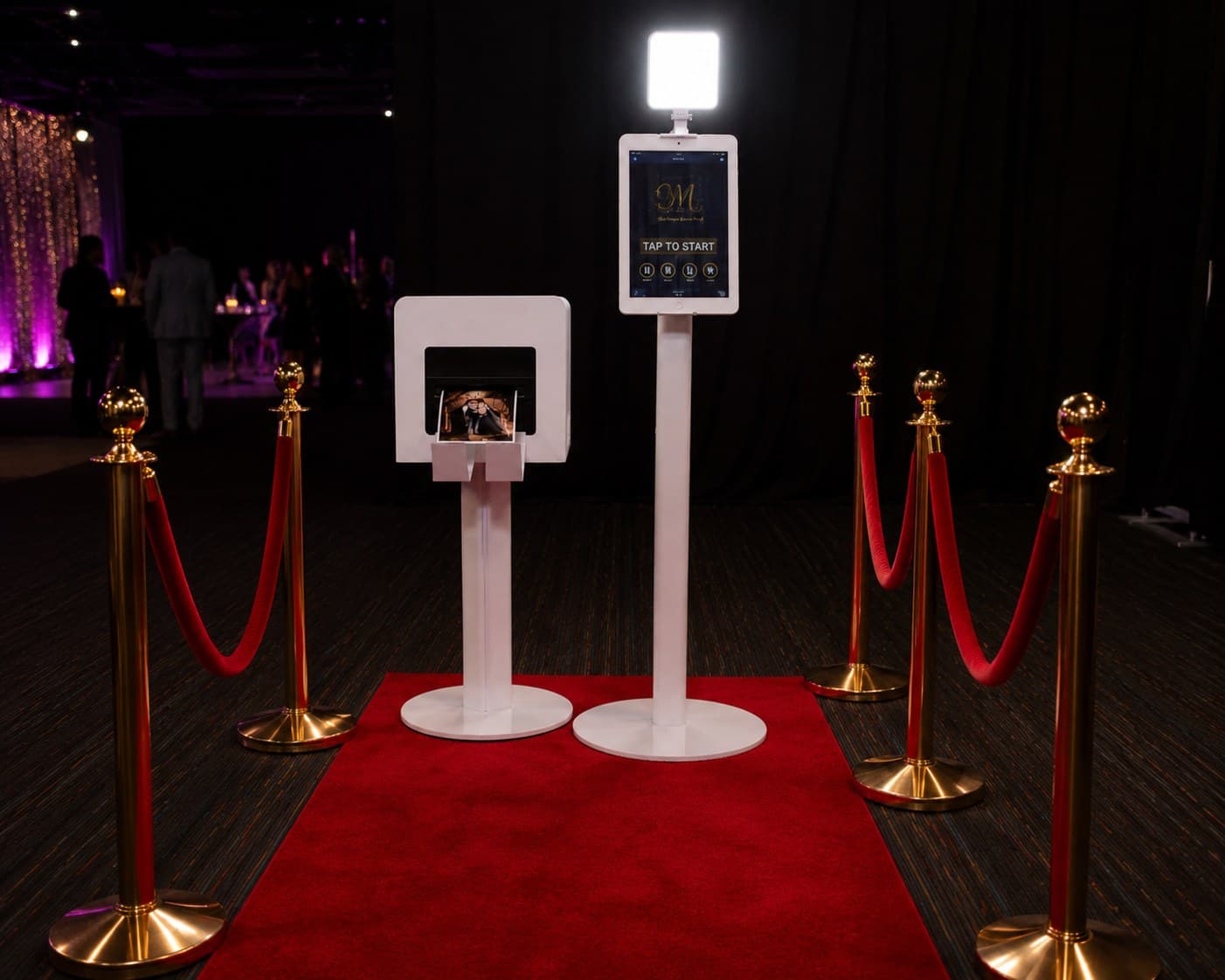 The Moment & More photo booth on a red carpet with gold stanchions at an event
